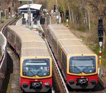 Zwei S-Bahnen vor einer Station.